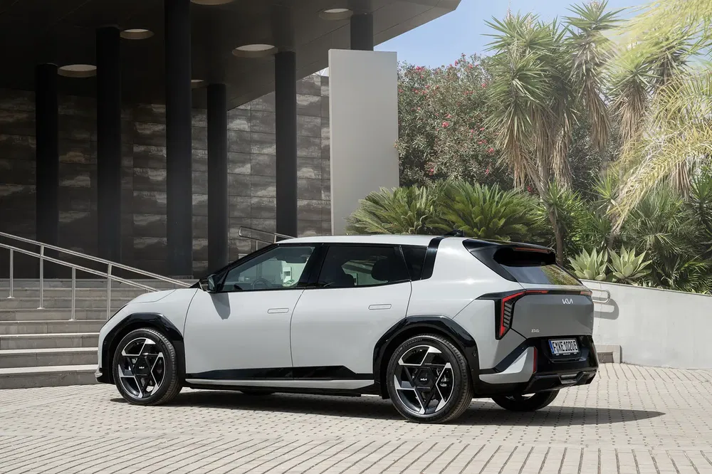 Kia EV9 électrique stationné devant un bâtiment moderne, design audacieux et futuriste.