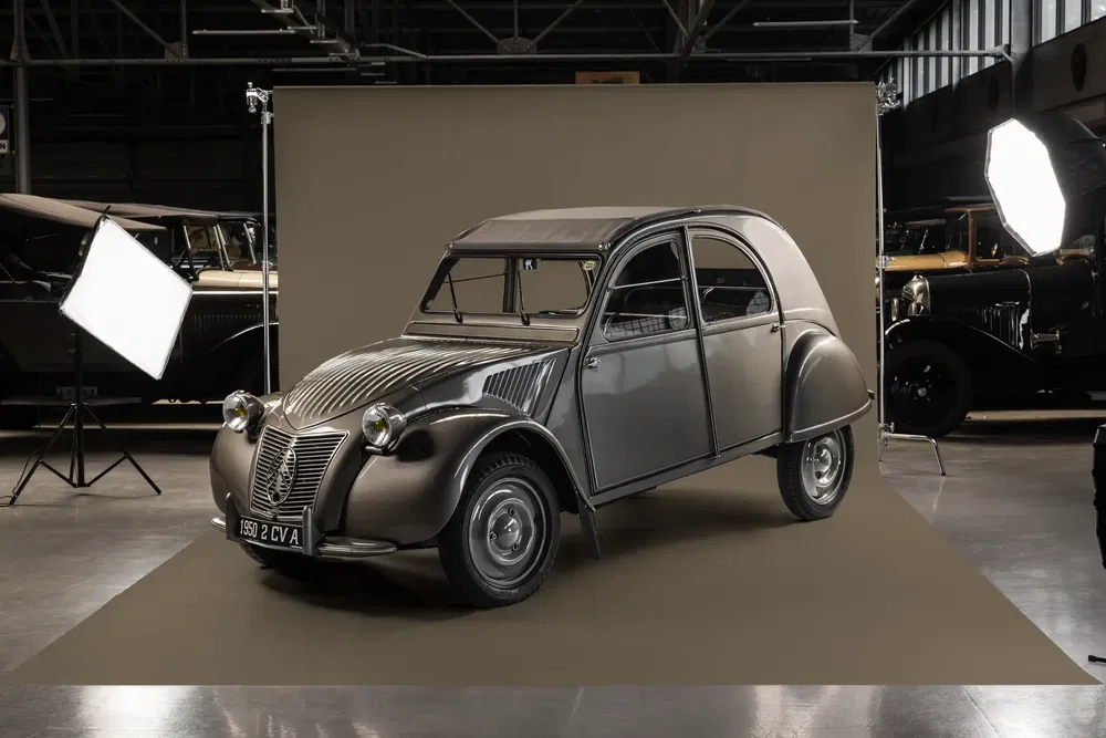 Citroën 2CV vintage dans un studio, éclairage professionnel pour une séance photo classique.