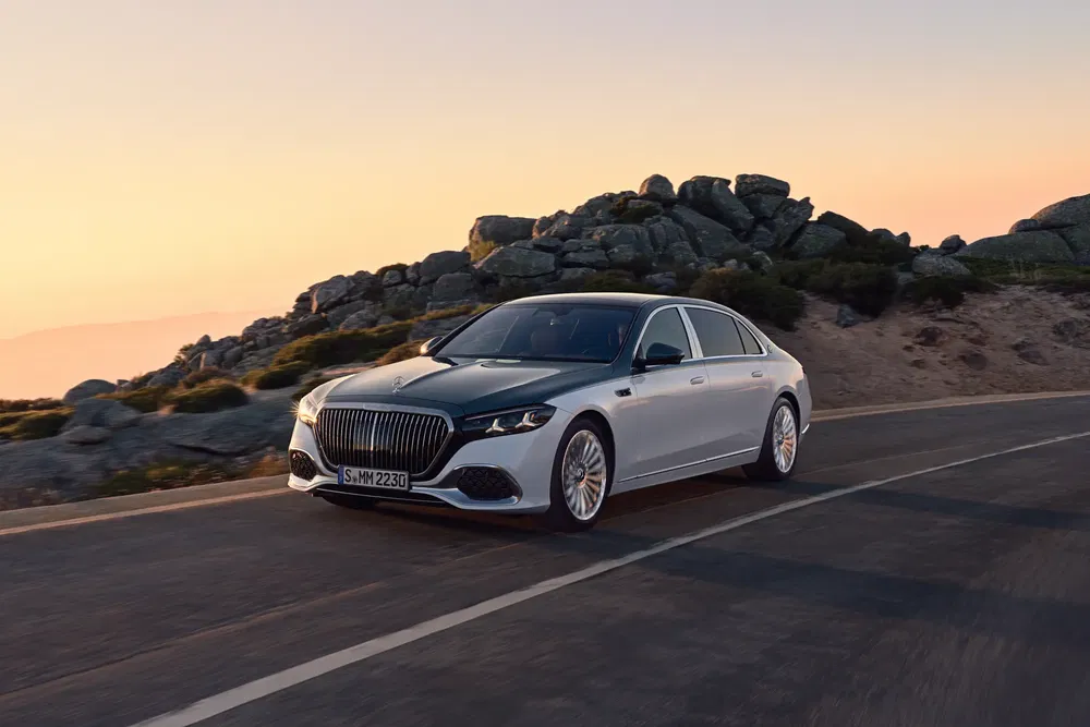 Mercedes-Maybach S-Class sur route montagneuse au coucher du soleil.