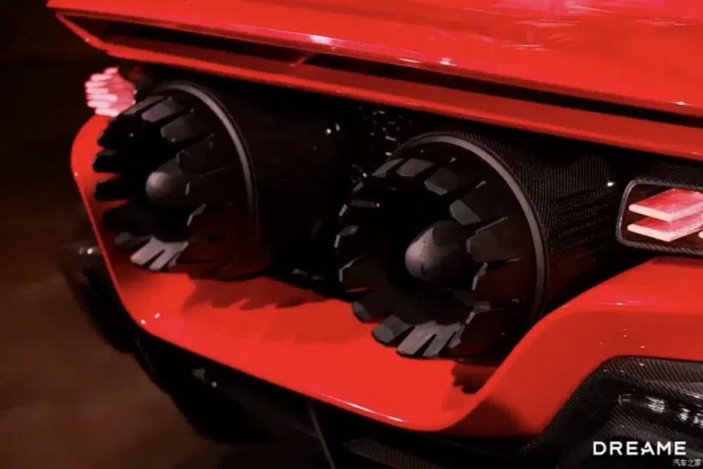 Gros plan arrière sur une voiture rouge avec échappement sportif et design futuriste.