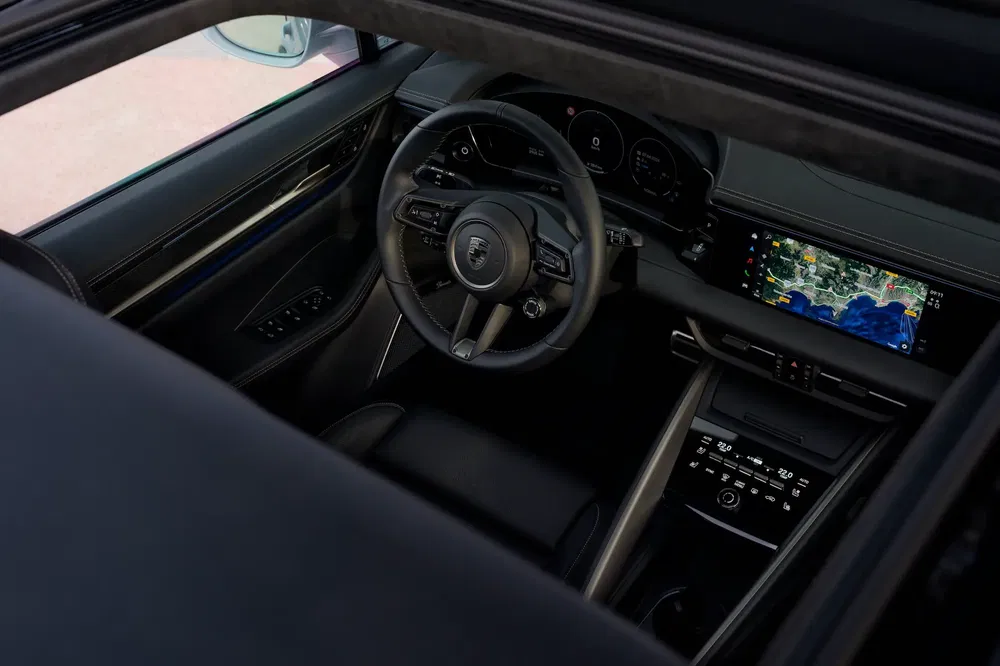 Intérieur d'une Porsche moderne avec volant sportif et écran de navigation numérique.