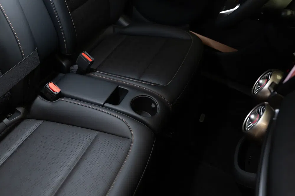 Moderne auto-interieur met zwarte lederen stoelen en bekerhouders.