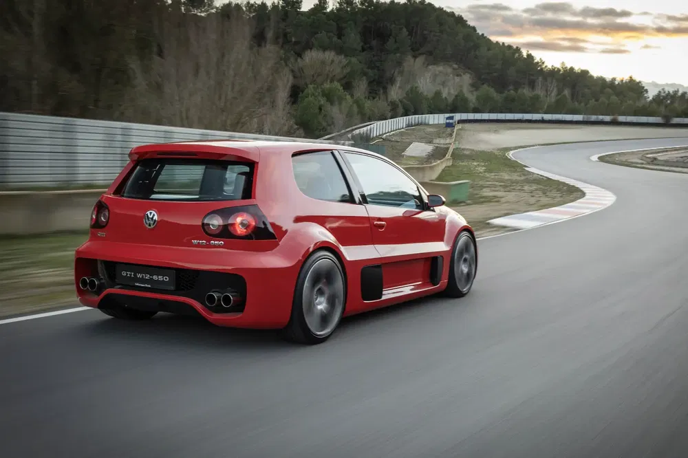 Volkswagen GTI W12-650 rouge sur circuit, courbe serrée, arrière dynamique.