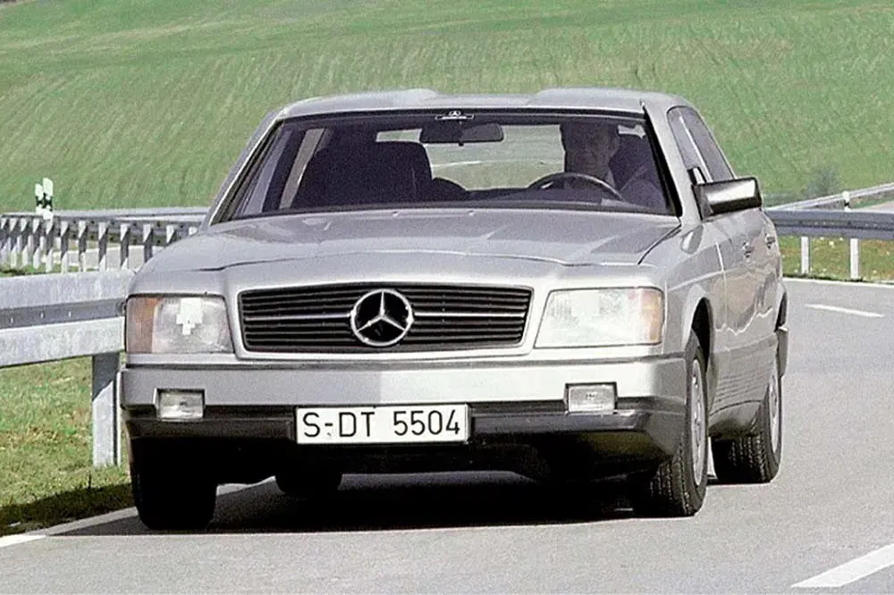 Zilverkleurige Mercedes-Benz op een landelijke weg, klassiek model met nummerplaat S-DT 5504.