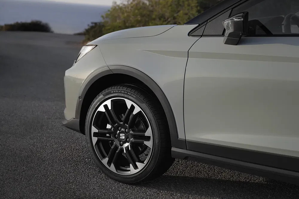 Zijaanzicht van een Honda HR-V met stijlvolle zwarte velgen op een rustige weg.