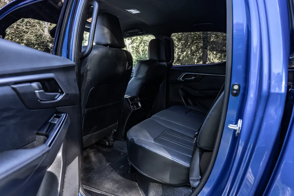 Intérieur spacieux et moderne d'une voiture bleue avec sièges en cuir noirs et finitions élégantes.