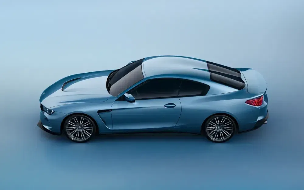Vue latérale d'une BMW M2 bleue sur fond clair, soulignant son design sportif et aérodynamique.
