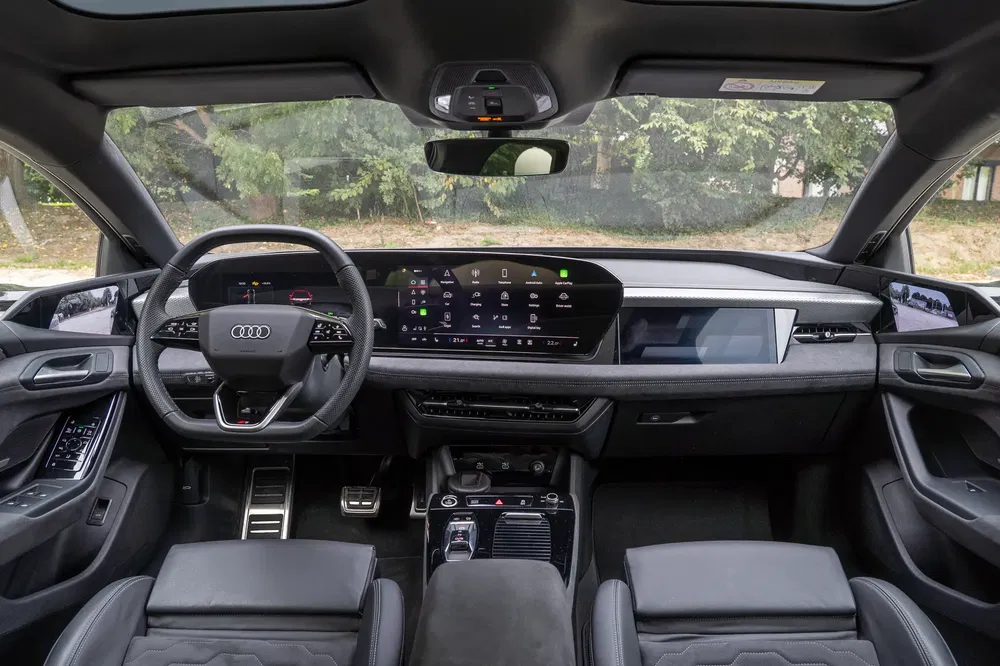 Intérieur de l'Audi Q6 e-Tron avec tableau de bord numérique et finitions luxueuses.