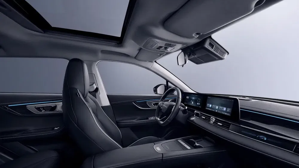 Intérieur moderne de voiture électrique avec tableau de bord numérique et toit ouvrant panoramique.