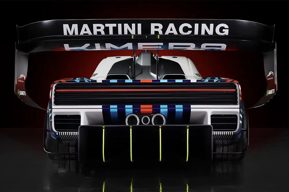 Voiture de sport Kimera EVO37 avec livrée Martini Racing, vue arrière et aileron imposant.