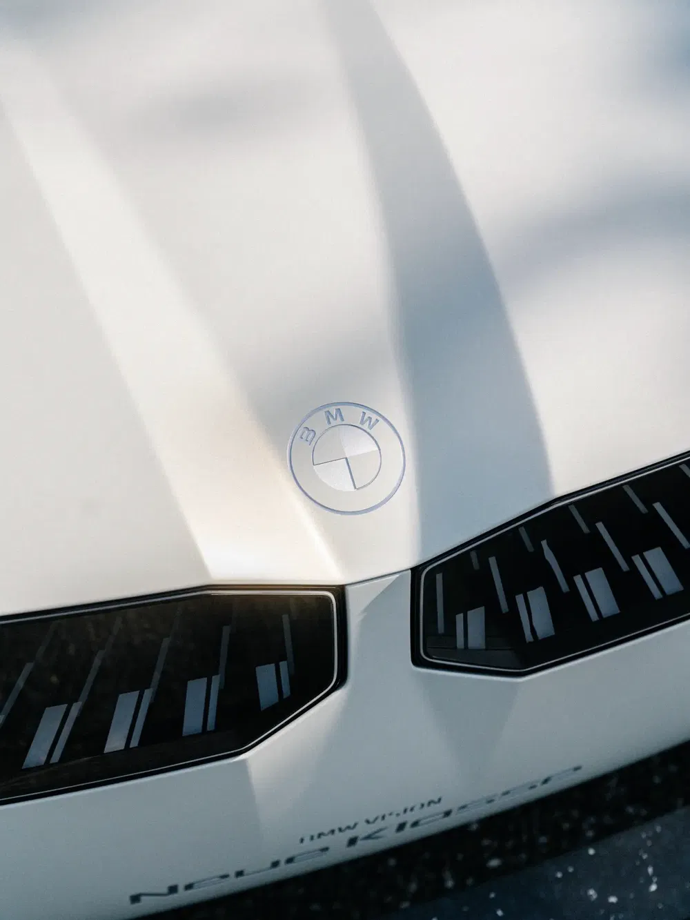 Capot de la BMW Neue Klasse concept, logo BMW sur fond blanc élégant.
