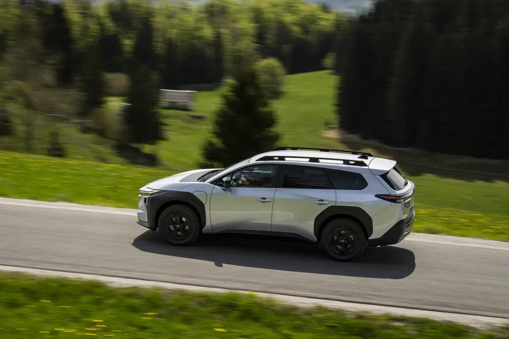 SUV Citroën C5 X roule sur une route de campagne verdoyante et vallonnée.