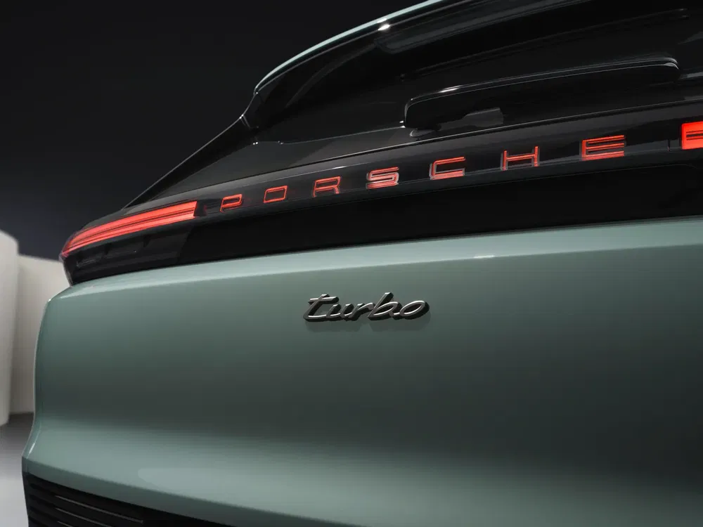 Achterkant Porsche Turbo-detail, verlicht logo, moderne sportieve uitstraling, metallic groene kleur.