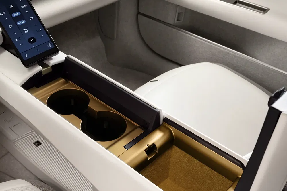 Interieur Volvo EM90 met wit-gouden middenconsole en geïntegreerd touchscreen in zicht.