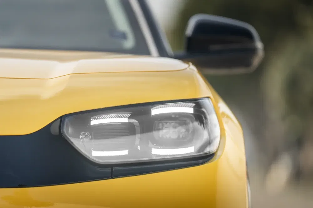 Gros plan sur phare avant Honda jaune moderne, design élégant et lumineux.