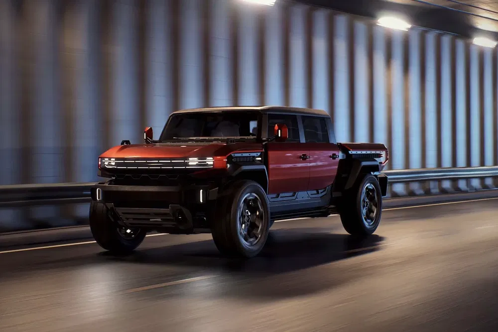 GMC Hummer EV rouge traversant un tunnel éclairé, affichant son design robuste et moderne.