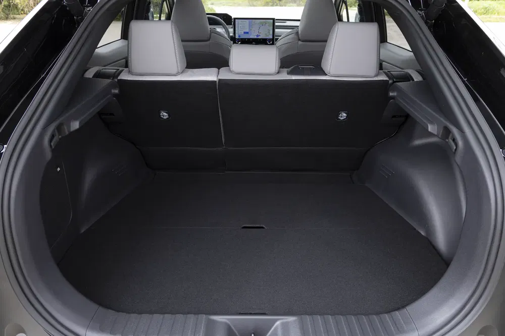 Ruime kofferbak van moderne elektrische SUV met neerklapbare stoelen en zichtbaar centraal scherm.