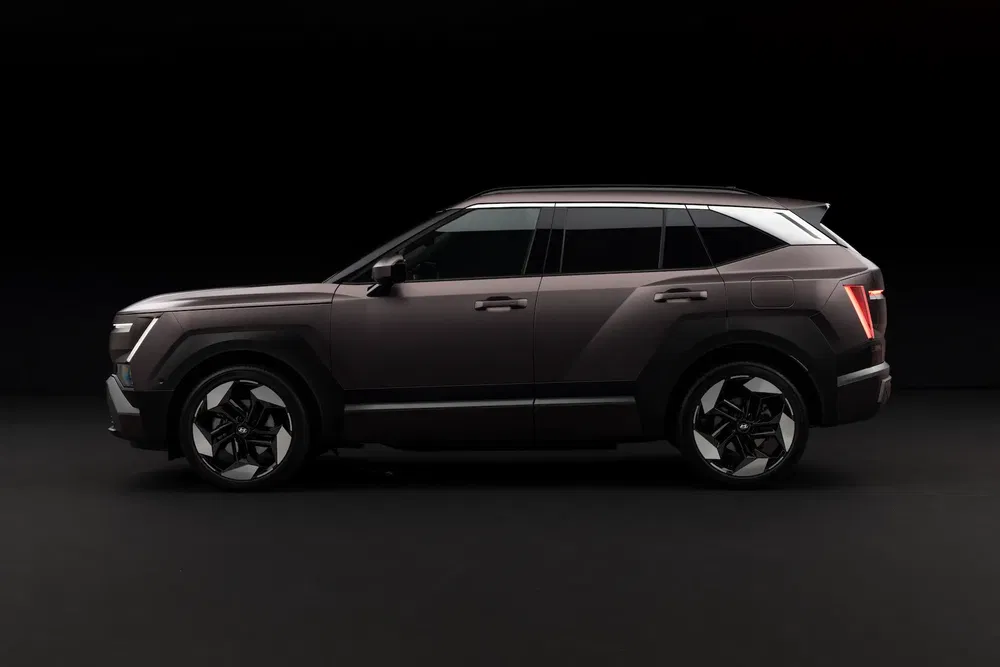 Profil latéral d'un SUV moderne sur fond noir, ligne de design angulaire et élégante.