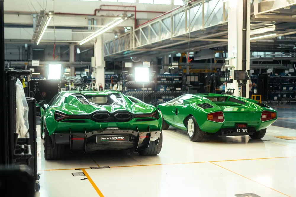 Twee groene Lamborghini's tonen hun gedurfde ontwerp in een modern, goed verlichte fabriekshal.