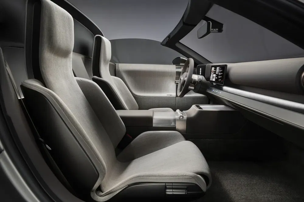 Futuristisch interieur van een elektrische Tesla met minimalistische zetels en digitaal dashboard.