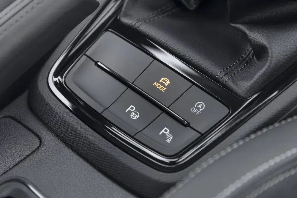 Console centrale de voiture avec boutons de mode et fonctionnalités d'assistance au stationnement.