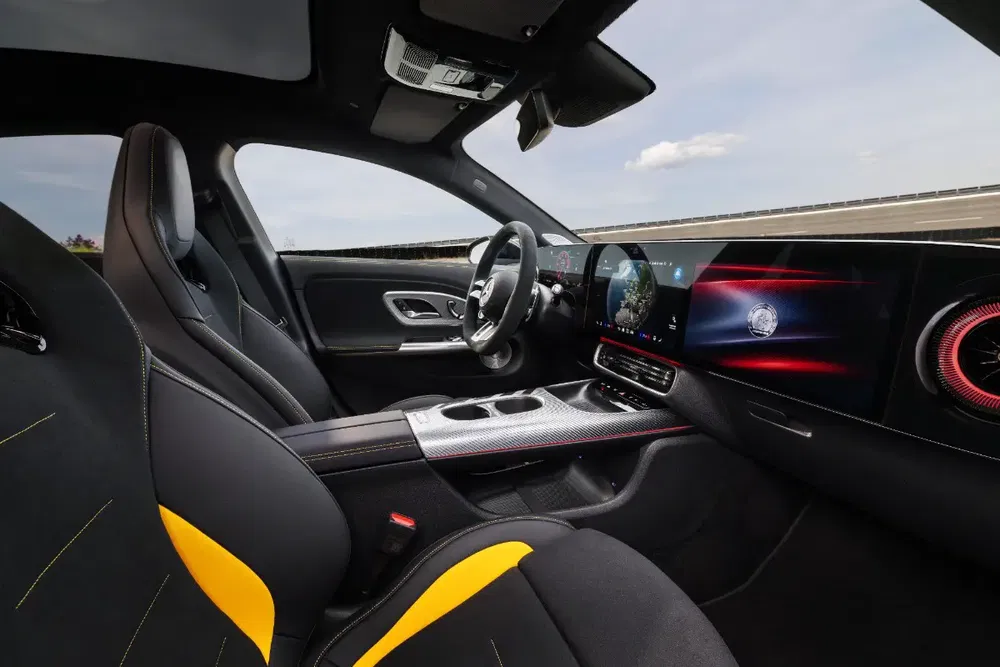 Modern interieur van een Mercedes-Benz auto met sportstoelen en panoramisch digitaal dashboard.