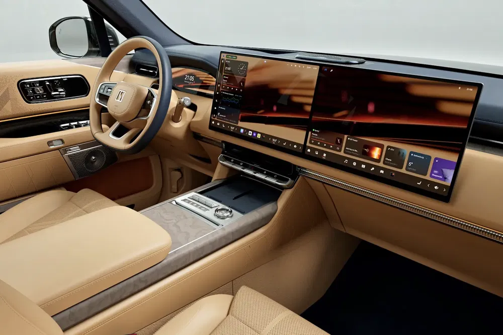Intérieur luxueux de voiture avec tableau de bord numérique, finitions en cuir beige.