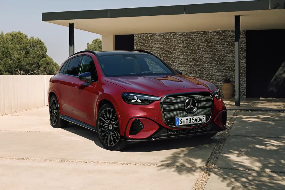 Rode Mercedes-Benz geparkeerd voor een modern huis, elegant en sportief ontwerp.