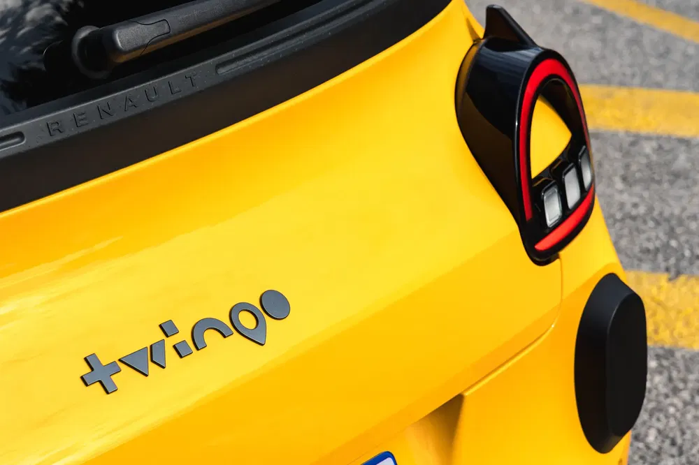 Detail van de achterkant van een gele Renault Twingo met kenmerkend logo en gestileerd achterlicht.