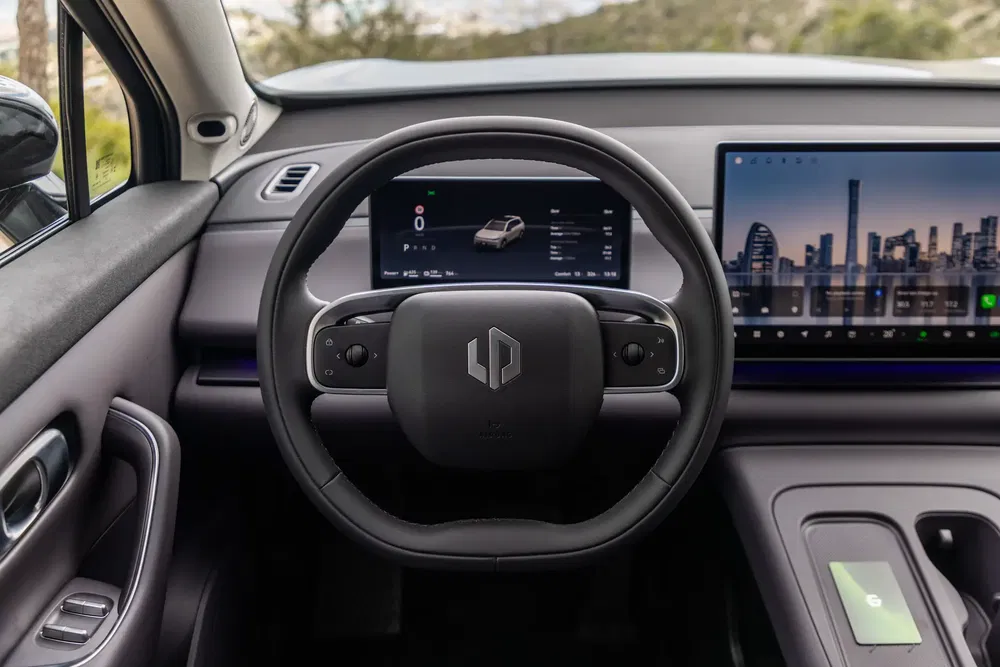 Modern autointerieur met stuur en twee hoogwaardige digitale schermen.