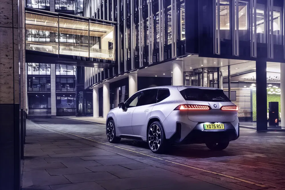 {"fr":"BMW iX blanche garée dans un cadre urbain moderne et éclairé la nuit.","nl":"Witte BMW iX geparkeerd in een moderne stadsomgeving bij nachtelijke verlichting."}