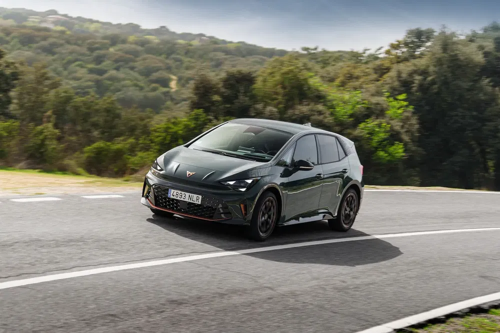 {"fr":"Cupra Born électrique roulant rapidement sur une route sinueuse entourée de verdure.","nl":"Elektrische Cupra Born rijdt snel op kronkelende weg omgeven door groen."}