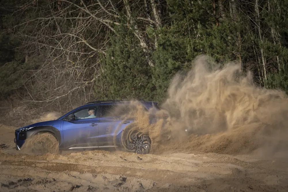{"fr":"SUV bleu conduisant sur sable, projetant un nuage de poussière, entouré d'arbres.","nl":"Blauwe SUV rijdt door zand, werpt stofwolk op, omgeven door bomen."}