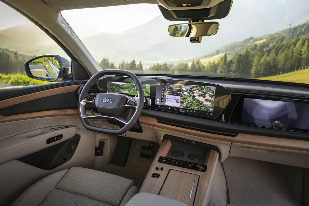 Intérieur moderne Audi avec tableau de bord numérique et volant élégant, vue panoramique en arrière-plan.