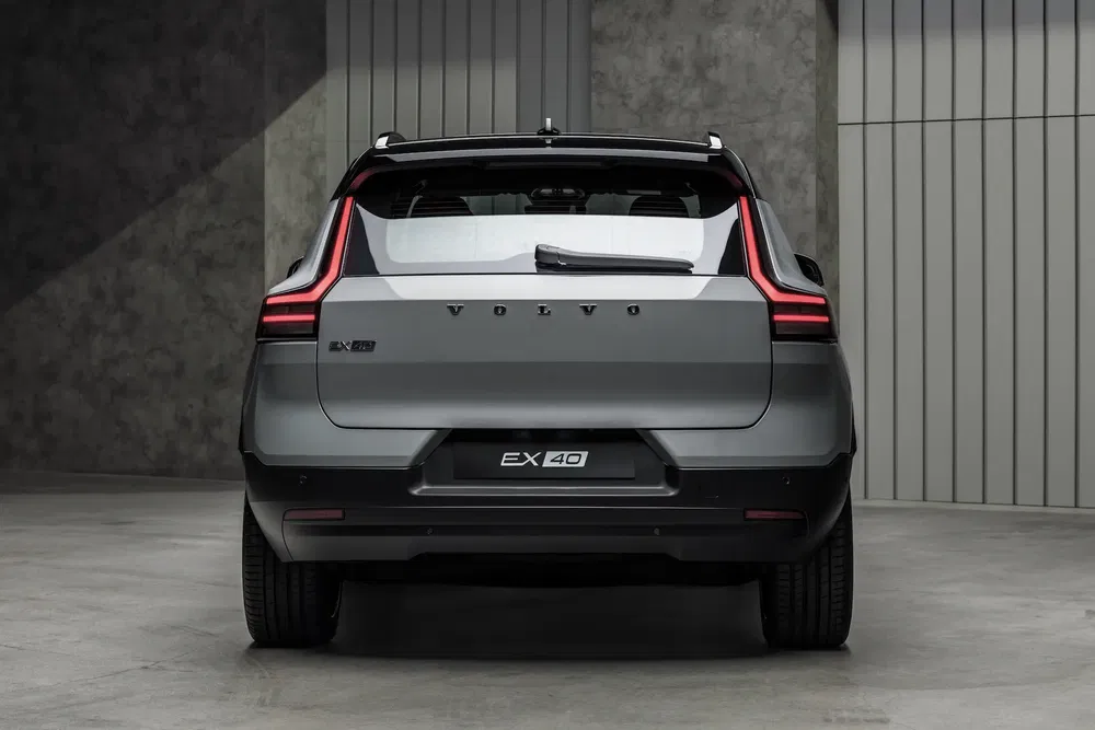 Vue arrière du SUV électrique Volvo EX40 gris dans un garage moderne.