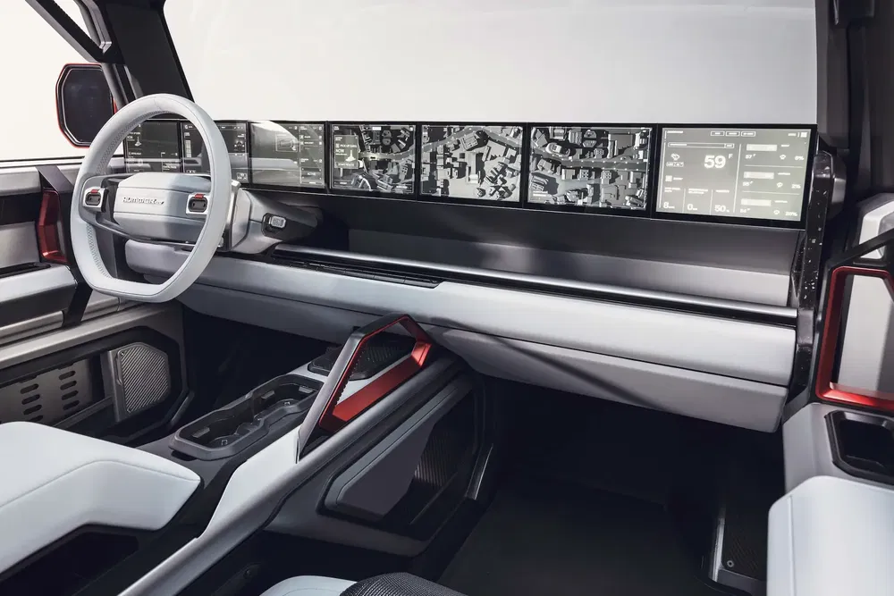Habitacle moderne du GMC Sierra EV avec écran tactile panoramique et volant futuriste.