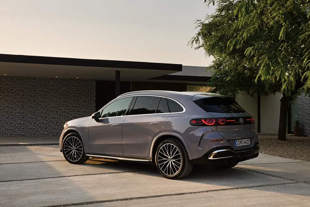 Mercedes EQ elektrische SUV geparkeerd voor een modern huis bij zonsondergang.