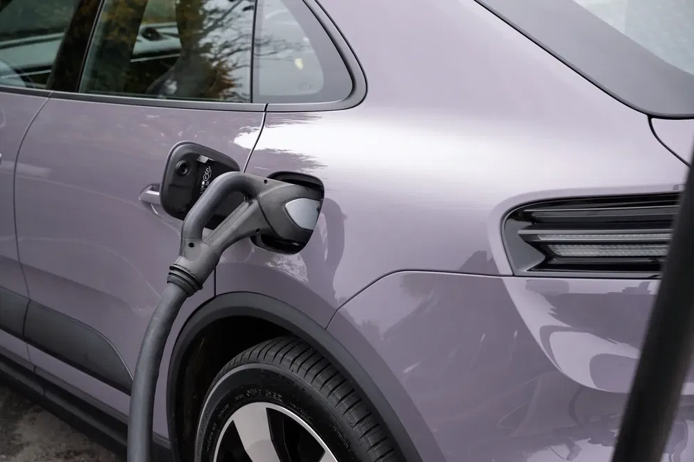 Voiture électrique Audi en charge, câble branché sur une Audi Q4 e-tron violette.