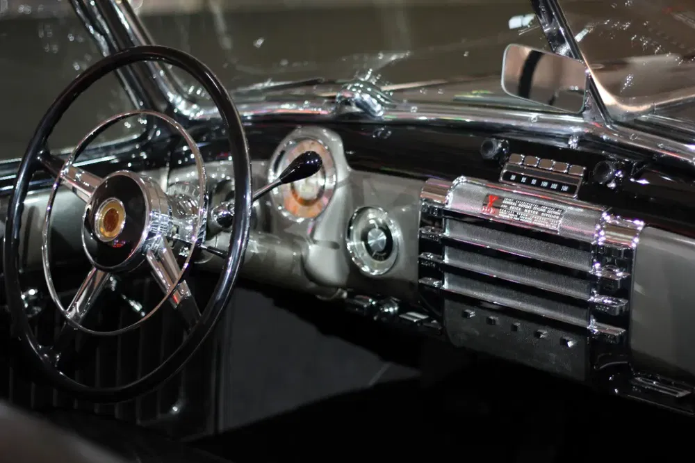 Intérieur de voiture classique avec volant et tableau de bord chromé rétro.