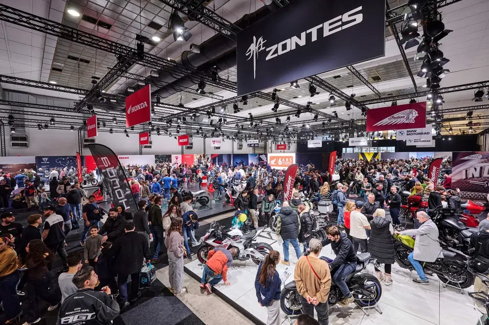 {"fr":"Salon de la moto avec stands Zontes, Honda, et Indian, nombreux visiteurs explorant les modèles.","nl":"Motorbeurs met Zontes, Honda en Indian stands, drukke menigte verkent modellen."}