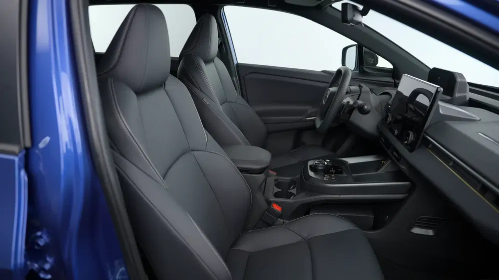 Intérieur de voiture électrique, sièges avant en cuir noir avec design moderne et tableau de bord numérique.