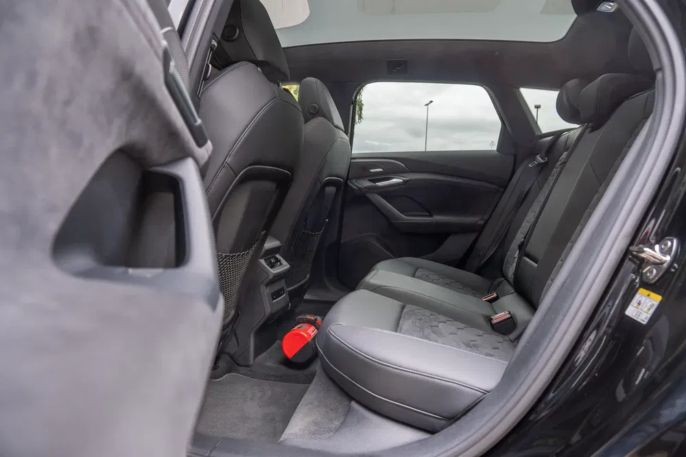 Intérieur spacieux d'une BMW, sièges arrière en cuir noir élégants et confortables.