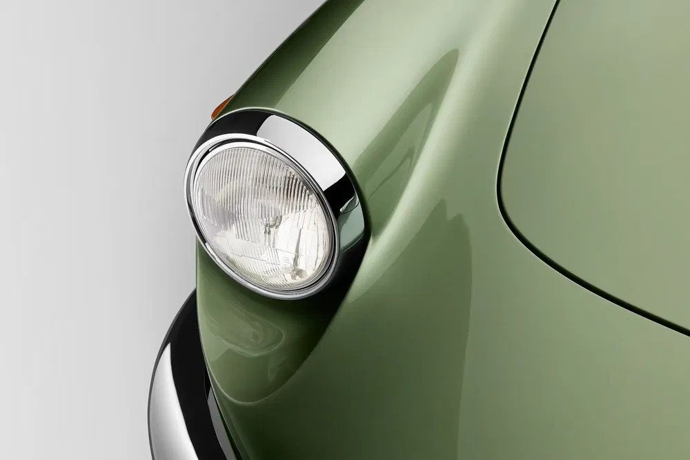 Phare avant d'une Porsche 911 classique verte, design emblématique et élégant.