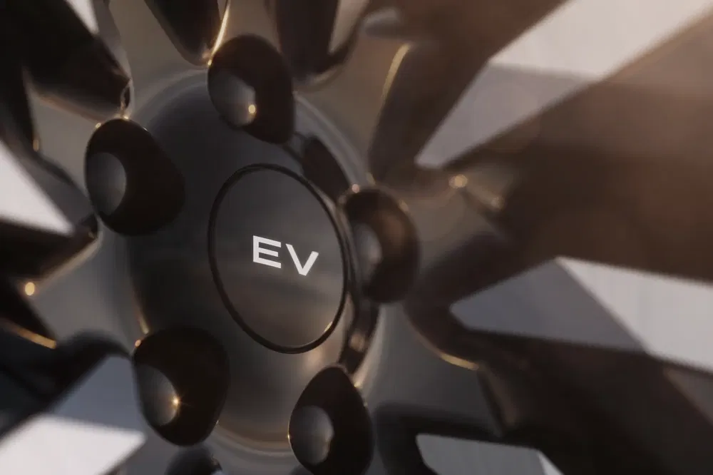 {"fr":"Gros plan sur roue d'une voiture électrique avec moyeu marqué 'EV'.","nl":"Close-up van wiel van elektrische auto met naaf gemarkeerd 'EV'."}