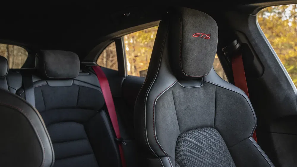 Intérieur de voiture de luxe avec sièges en cuir GTS et ceintures rouges distinctives.