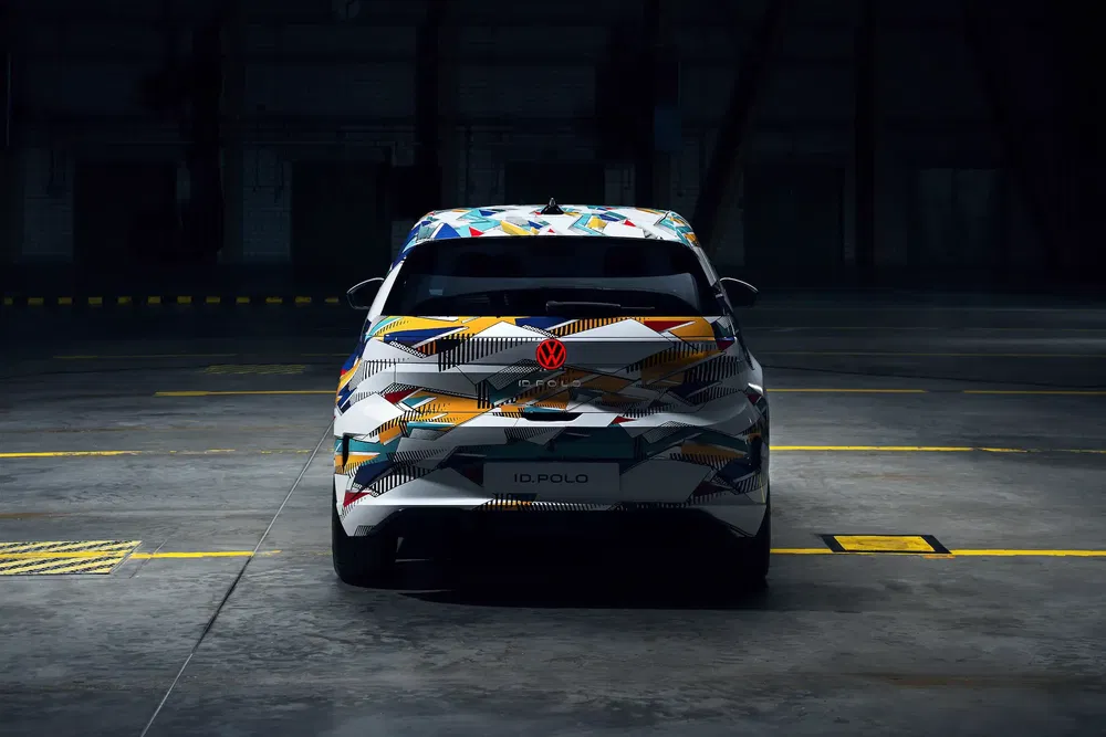 Volkswagen ID. Polo avec camouflage coloré dans un entrepôt sombre.