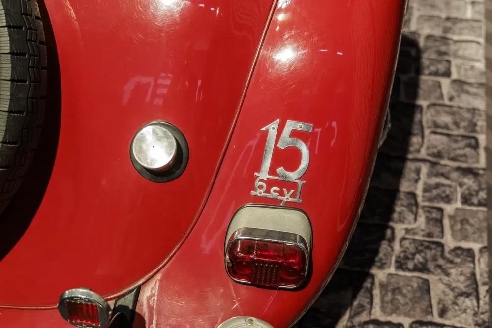 Derrière d'une Citroën Traction Avant 15, rouge, sur route pavée.