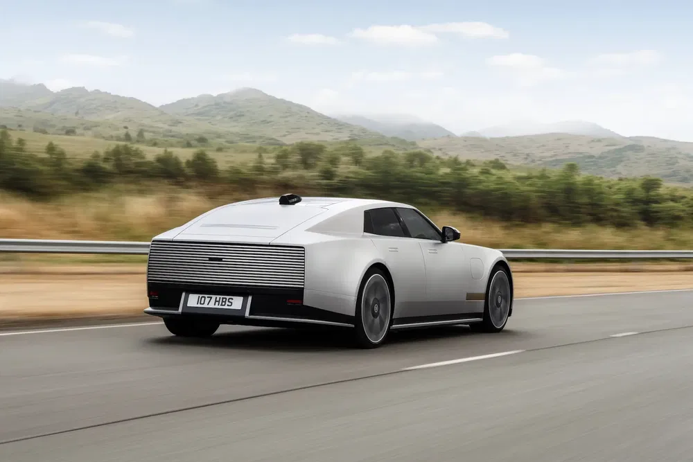 Moderne Rolls-Royce conceptauto op weg, futuristisch ontwerp, innovatieve achterkant, in beweging.