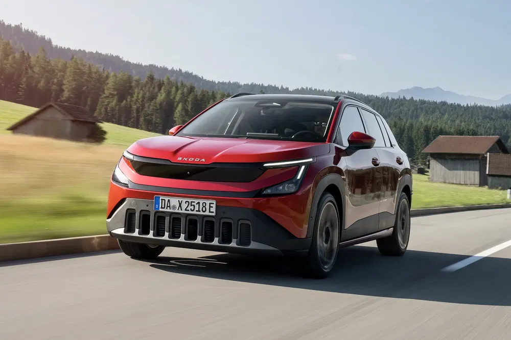 SUV Skoda moderne rouge roulant sur une route de campagne pittoresque.