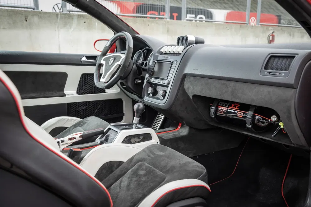 Intérieur de Volkswagen Golf GTI avec sièges sport et tableau de bord personnalisé.